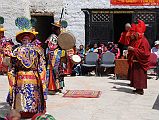 Mustang Lo Manthang Tiji Festival Day 2 03-2 Dorje Jono Prays To Senior Monks Dorje Jono prays to a couple of senior monks near the start of day 2 of the Tiji Festival in Lo Manthang. The tourist check-post and information center in the background has Internet access.